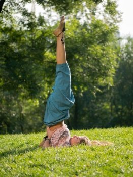 Young yogi woman in birch stand in park. Yoga time. Green grass, park, summer morning. Relaxing and meditating, Health concept. High quality photo. Young yogi woman in birch stand in park. Yoga time. Green grass, park, summer morning. Relaxing and meditating, Health concept.