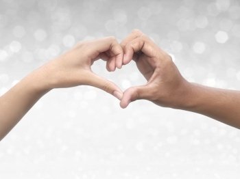 Couple making heart shape with hand on shining bokeh background