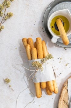 Breadsticks grissini. Bread sticks with sesame seeds, oregano and olive oil and balsamic vinegar on kitchen countertop. Top view. Flat lay with copy space