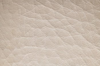 White cream artificial or synthetic leather background with neat texture and copy space, colorful fabric sample with leather-like finish aimed for upholstery, fashion, sewing or footwear projects