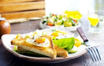 Sandwich with Fried Egg, fresh salad with eggs and toast. Sandwich with Fried Egg and salad on plate
