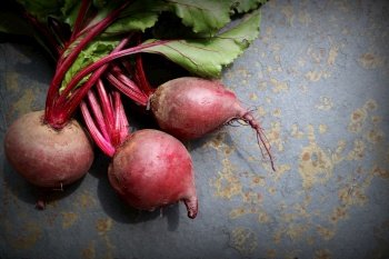 Fresh beetroot with leaves on a grey stone background. Healthy food. Top view. Free space for your text.. Fresh beetroot with leaves on a grey stone background. Healthy food. Top view. Free space for your text