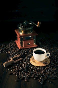 Cup of coffee and beans on wooden table. Homemade coffee at table background
