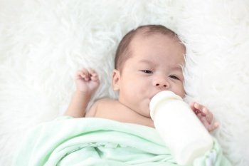 Newborn babies suck milk at the bottle.