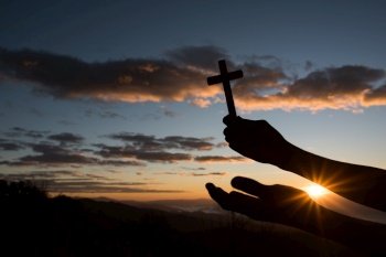 Silhouette of Hand hold cross of God