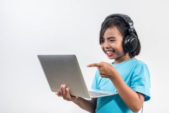Little girl using laptop computer and listening lesson online 