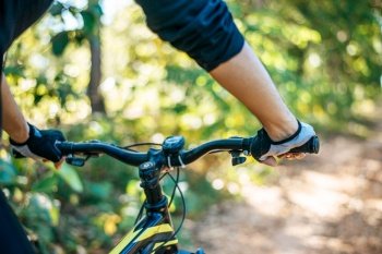 Mountain cyclists grasp the bike handle, focus on gloves