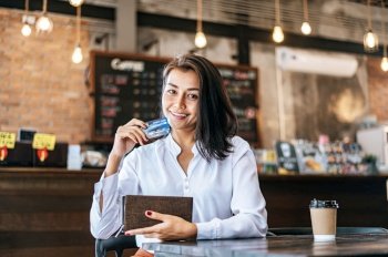 Accepting credit cards from a brown purse to pay for goods on coffee orders.