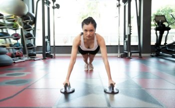 Women exercising by pushing the floor with Fitness Push Up Stands in gym