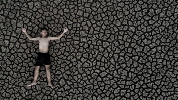 Boys sleep on dry land with dry and cracked soil, global warming