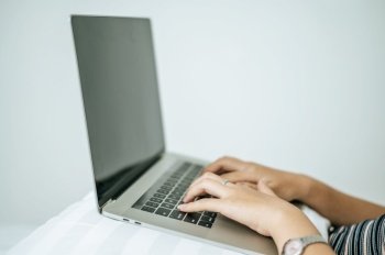 A woman’s hand that is placed on a laptop. Selective focus.