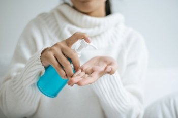 Young women clean their hands with a hand wash gel to prevent germs.
