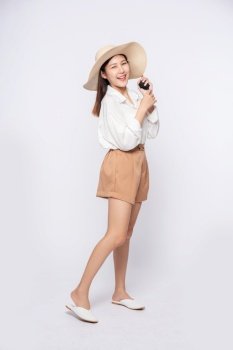 Young woman wearing a white shirt and shorts, wearing a hat and handle on the hat.
