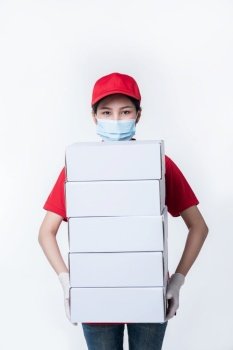 Image of a conscious young delivery man in red cap blank t-shirt uniform face mask gloves standing with empty white cardboard box isolated on light gray background studio, Service during pandemic coronavirus virus covid-19 concept



