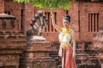 Portrait Charming Thai woman in Beautiful traditional dress costume, woman wearing typical thai dress in archaeological site or thai temple background, identity culture of thailand
