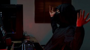 Hacker in hoodie raising hands while having problem with hacking programming system or server.
