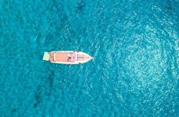 Aerial view of beautiful luxury yacht in blue sea in summer sunny day. Sardinia, Italy. Top drone view of speed boat, sea coast, transparent azure water. Travel. Tropical landscape. Yachting. Seascape