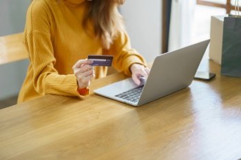 Woman shopping on laptop holding credit card for Internet online e-commerce shopping spending money Online shopping Mobile phone laptop technology