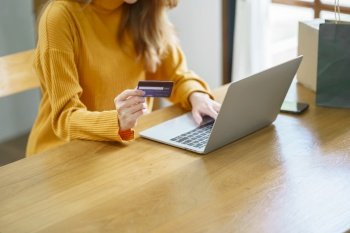 Woman shopping on laptop holding credit card for Internet online e-commerce shopping spending money Online shopping Mobile phone laptop technology