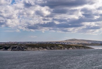 Cityscape of the town of Stanley on the Falkland Islands from the ocean. Entering the bay of Port Stanley on Falkland Islands on sunny day