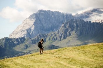 A girl hiking on Dolomites mountains, in alto adige, Val badia, with marmolada landscape on background