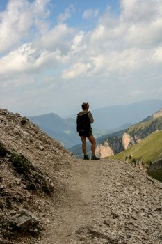 a girl hiking on Dolomites, Puez Odle natural park,  in  Alto Adige, Val Badia