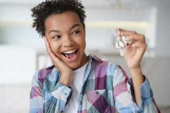 Excited african american teen girl tenant showing keys of first new house. Happy biracial female delighted with renting apartment holds home key. Relocation, real estate rental service.. Excited african american teen girl tenant showing keys of first new house. Real estate rent service