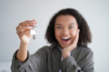 Excited woman showing keys of house, close-up focus on hand with key. Happy young girl tenant delighted with purchasing own apartment or relocating into new home. Real estate rental service concept.. Happy girl tenant show keys of new house. Close-up of hand with home key. Real estate rental service