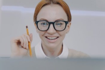 Young woman studying with camera. Happy student holding pencil and taking notes. Distance learning. Online remote study concept. Businesswoman, secretary or manager in glasses at workplace.. Young woman studying with camera. Happy student holding pencil and taking notes. Distance learning.