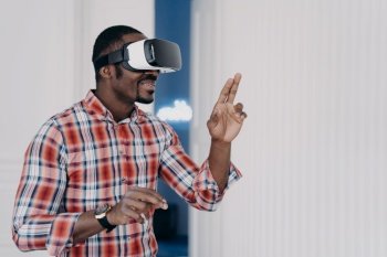 African american guy wearing virtual reality glasses, enjoying leisure free time in cyberspace. Modern black man playing video game simulation, testing purchase in online store. E commerce, tech. African american guy in virtual reality glasses test purchase in online store. Ecommerce, cyberspace