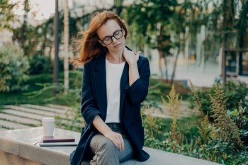 Young tired businesswoman massaging neck, feeling pain in body muscles because of bad posture at work, sitting in park after long working day in office, overworked female suffering from backache,. Young tired woman massaging neck, feeling pain in body muscles because of bad posture at work