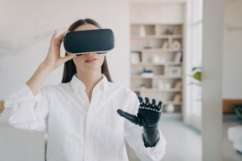 Pretty handicapped girl uses VR glasses at home. Futuristic medical tech aids in rehabilitation.