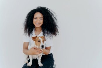 Cheerful woman with crisp hair plays and poses with pedigree dog, capturing a memorable moment. Humans and animals concept.