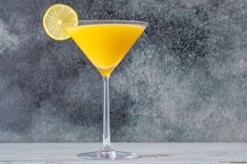 Glass of Frozen Mango Martini cocktail garnished with lime wheel