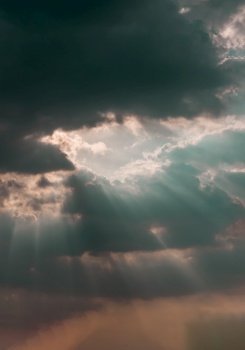 The sun’s rays passing through the clouds and shining form an interesting light pattern against the sky. Space for text, Selective focus.