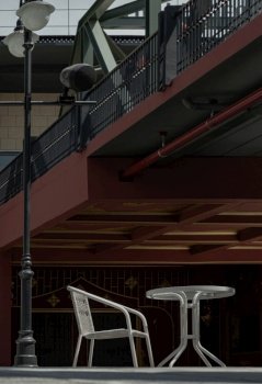Bangkok, Thailand - 26 Jan, 2023 - The white metal chair and the table beside street lamp pole, Relaxing corner under the bridge in the sunny day with good atmosphere, Space for text, Selective focus.
