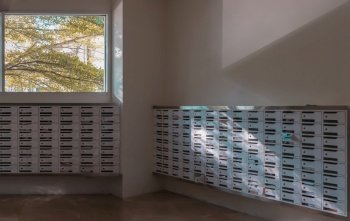 Bangkok, Thailand - 28 Jan, 2023 - Windows view with big tree background in White mailroom for resident in condominium or apartment. Postbox in condo, Light and shadow, Selective focus.