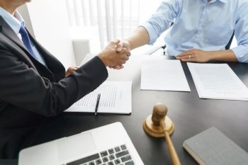 Lawyer and legal concept, Businessman and senior lawyer shake hands after successful deal contract.