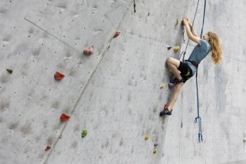 sport. bouldering, teen girl climbing up the wall

