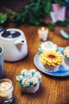 Various cupcakes decorated with colorful flower icing on wooden table, floral bouquet, wedding cake, High tea, Holiday concept Mothers day. Various cupcakes decorated with colorful flower icing on wooden table, floral bouquet, wedding cake, High tea, Holiday concept