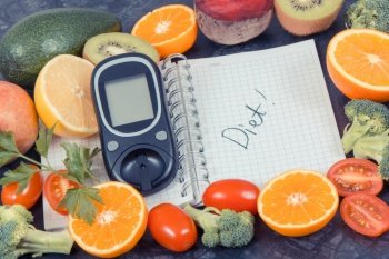 Word diet written in notepad, glucometer and fresh ripe fruits with vegetables, diabetes, healthy lifestyles and nutrition concept. Word diet written in notepad, glucometer and fruits with vegetables, diabetes and healthy lifestyles concept