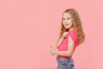 Vaccination concept. cute little girl, preschooler, with a band-aid on her shoulder, received a vaccine, protection against covid 19, and other diseases, stands on an isolated pink background, smiles. Vaccination concept. cute little girl, preschooler, with a band-aid on her shoulder, received a vaccine, protection against covid 19, and other diseases, stands on an isolated pink background, smiles.