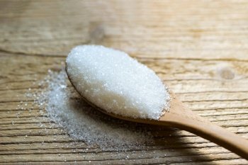 Sugar on spoon and wooden background, white sugar for food and sweets dessert candy heap of sweet sugar crystalline granulated