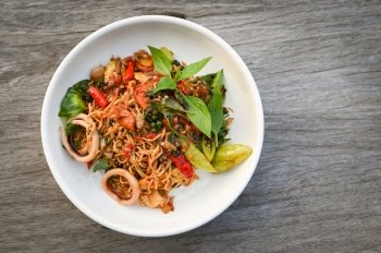 noodles plate with instant noodles stir fried with vegetables herb spicy tasty appetizing asian noodles mix seafood stir fried squid with basil and chilli pepper - top view 