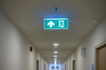 Fire Emergency exit sign on the wall background inside building. Safety concept
