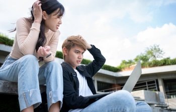 Asian students sitting on step are excited and stressed and disappointed after check exam results in computer laptops, Entrepreneurs disappointed after Project fall. Student lifestyle in university
