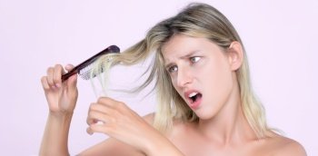 Alluring portrait of beauty cosmetic clean skin woman having brittle dry hair problem. Grimacing frustrated sad facial expression in pink isolated background. Damaged and hair loss concept.. Alluring portrait of woman with cosmetic skin having hair problem.