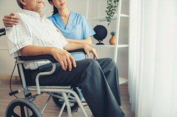 Caring nurse and a contented senior man in a wheel chair at home, nursing house. Medical for elderly patient, home care for pensioners.. Caring nurse and a contented senior man in a wheel chair at home.