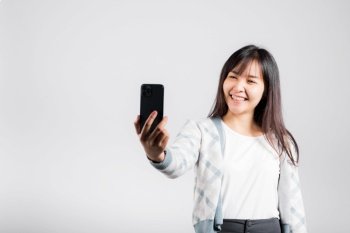 Woman excited holding smartphone to shooting selfie photo front camera studio shot isolated white background, happy young female smiling taking photography by mobile phone on mobile phone