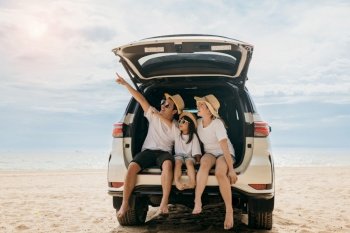 Happy Family Day. Family travel in holiday at sea beach, Dad, mom, daughter enjoy road trip sitting on back car and pointing finger out, people having fun in summer vacation on beach with automobile